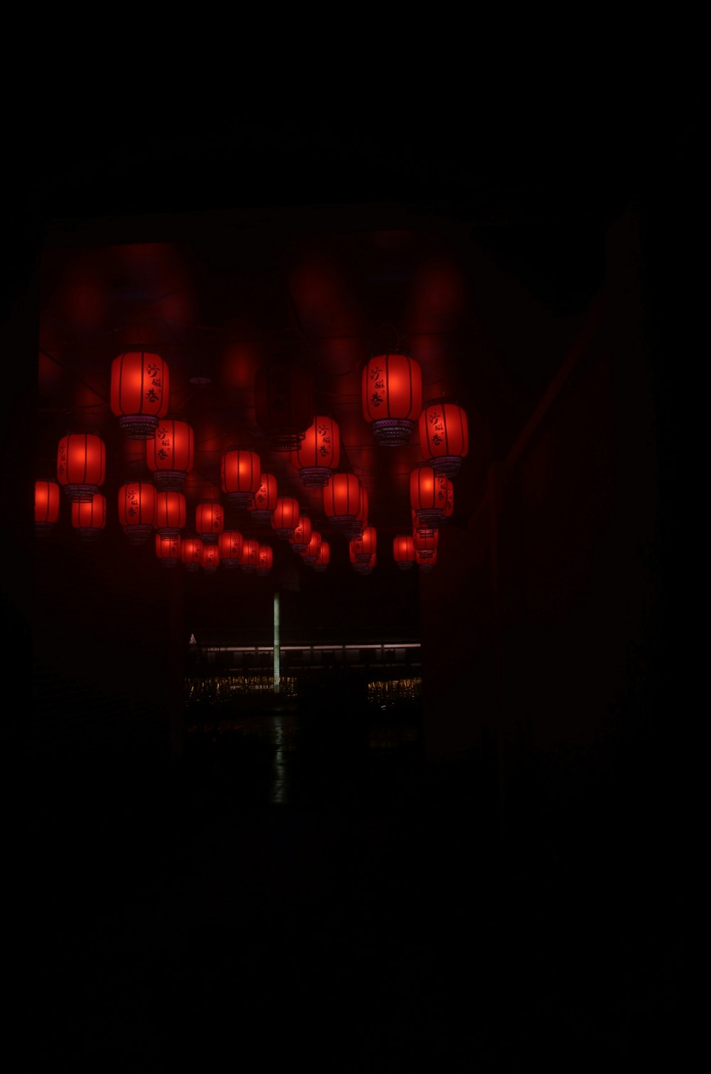 a group of red lanterns hanging from the side of a building