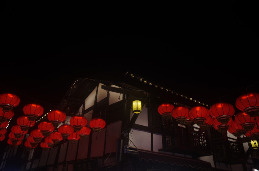 a row of red lanterns hanging from the side of a building