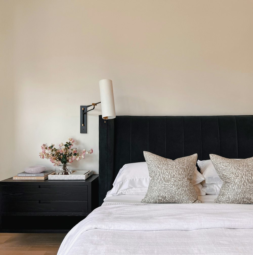 a bedroom with a black headboard and a white bed