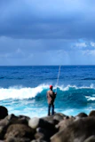Fisherman wearing breathable, durable fishing apparel standing by the sea.