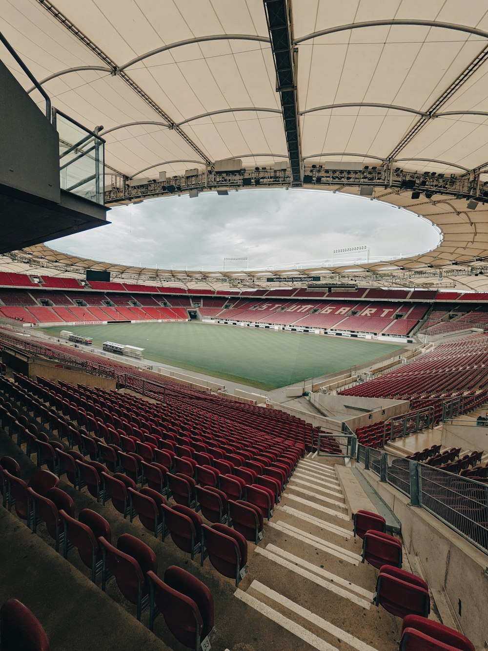 an empty stadium with red seats and a sky background