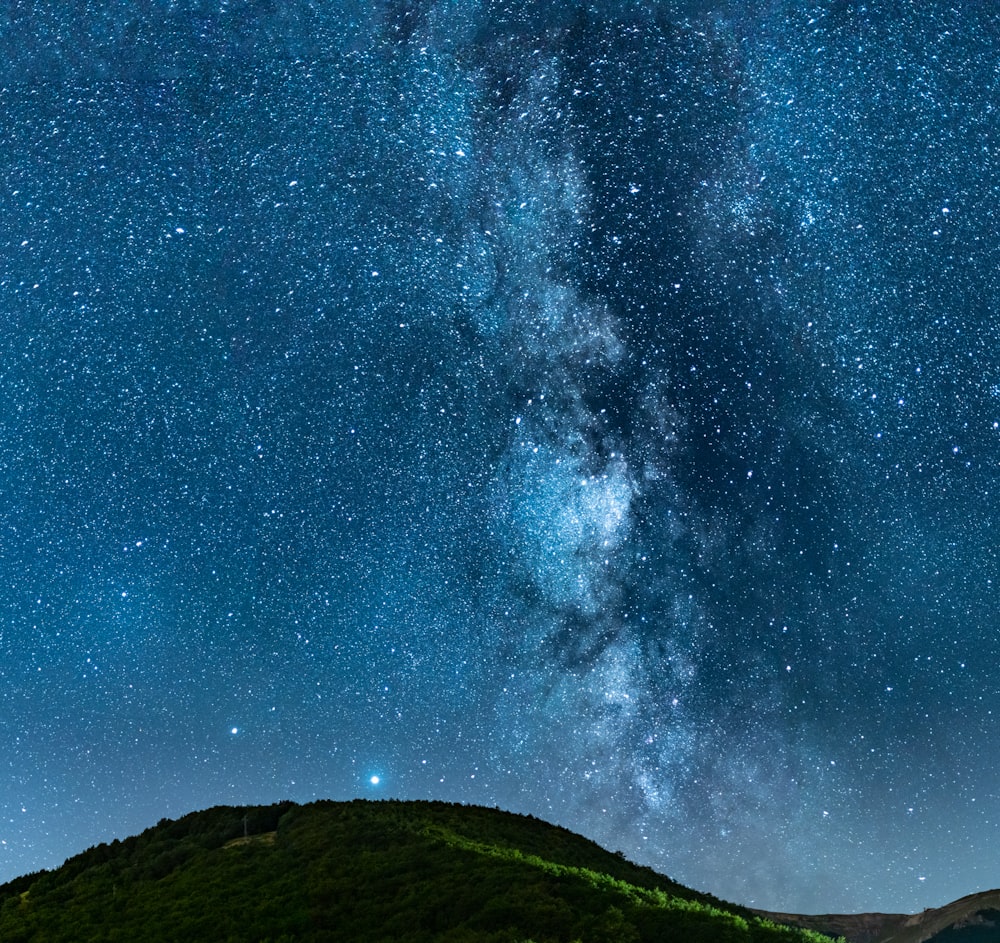 El cielo nocturno está lleno de estrellas sobre una montaña