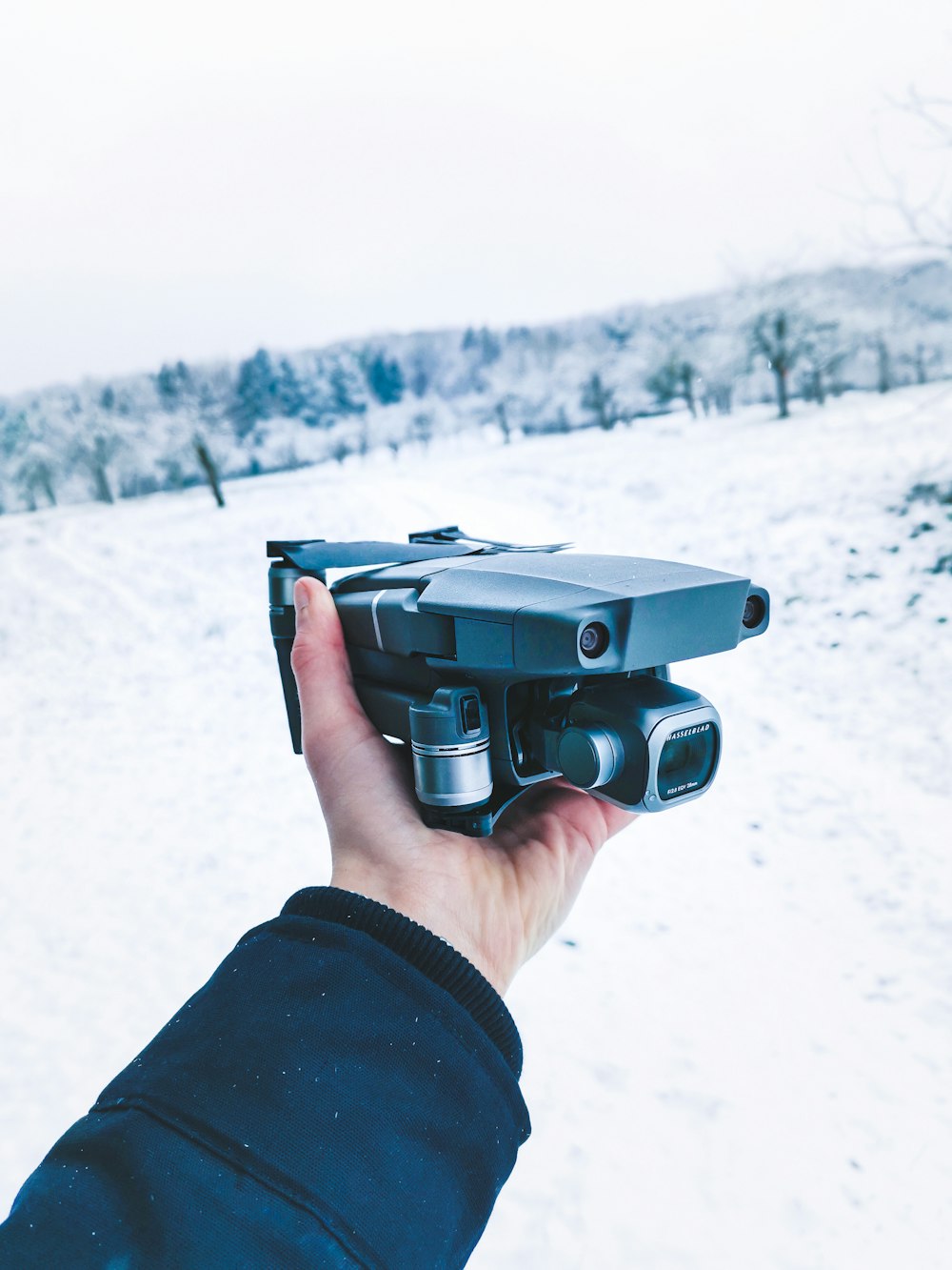 a person holding a camera in the snow