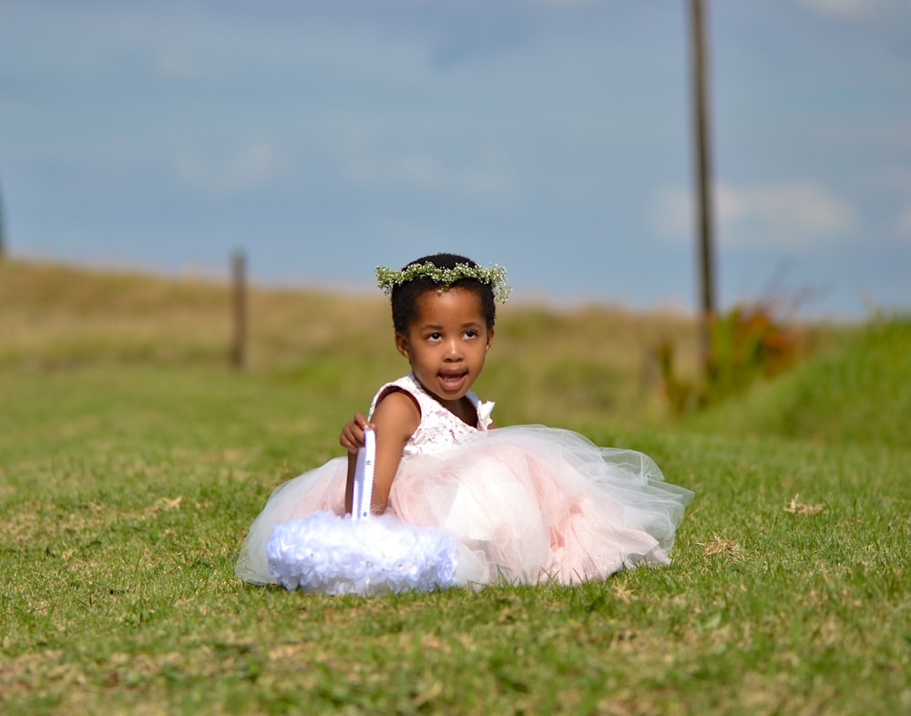 a little girl in a tutu laying on the grass