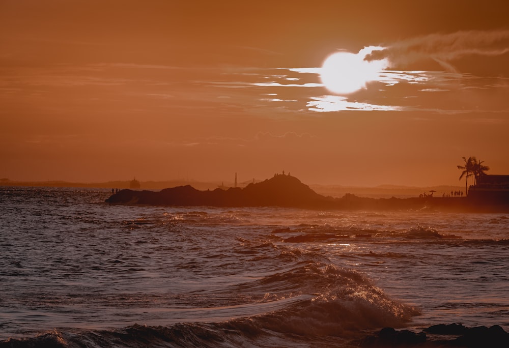 Il sole sta tramontando sull'oceano con le onde
