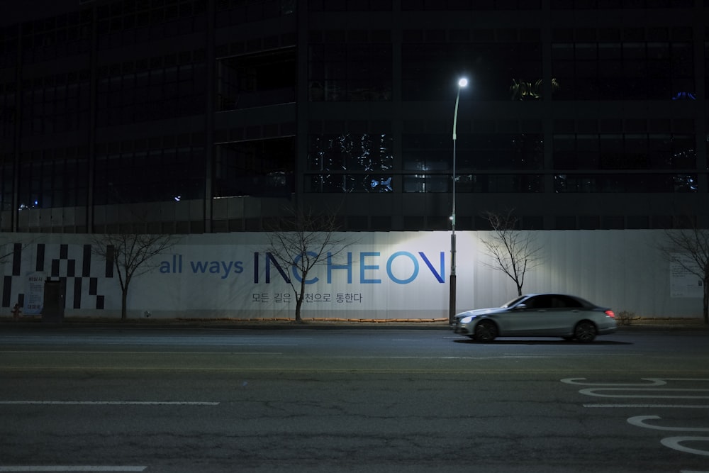 a car driving down a street at night