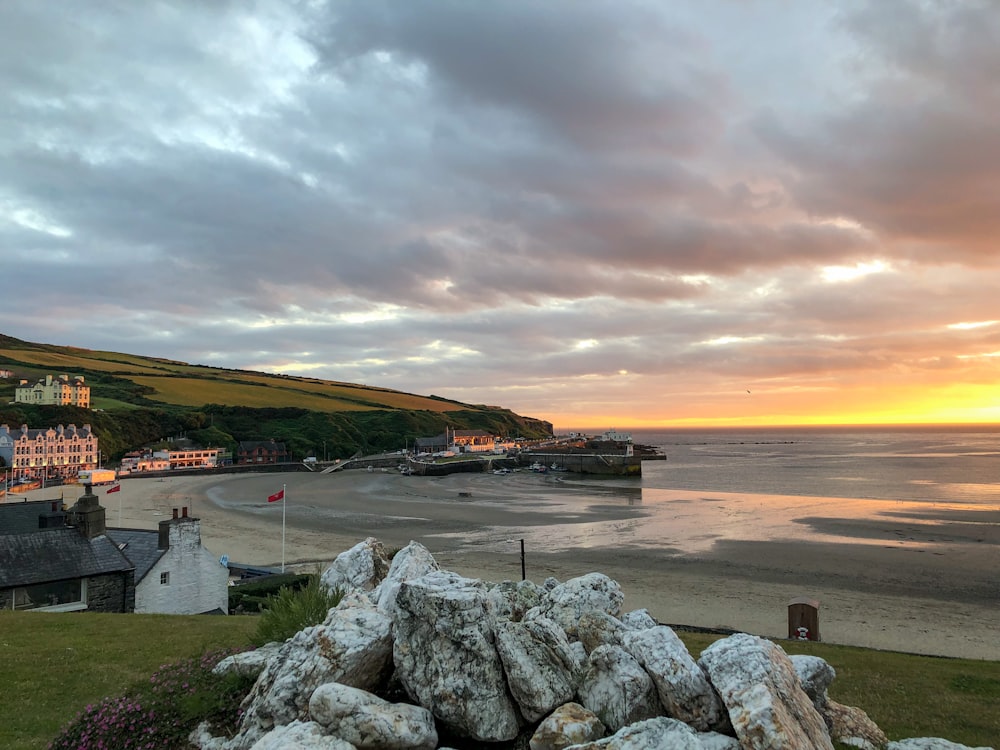 a view of a beach at sunset from a hill