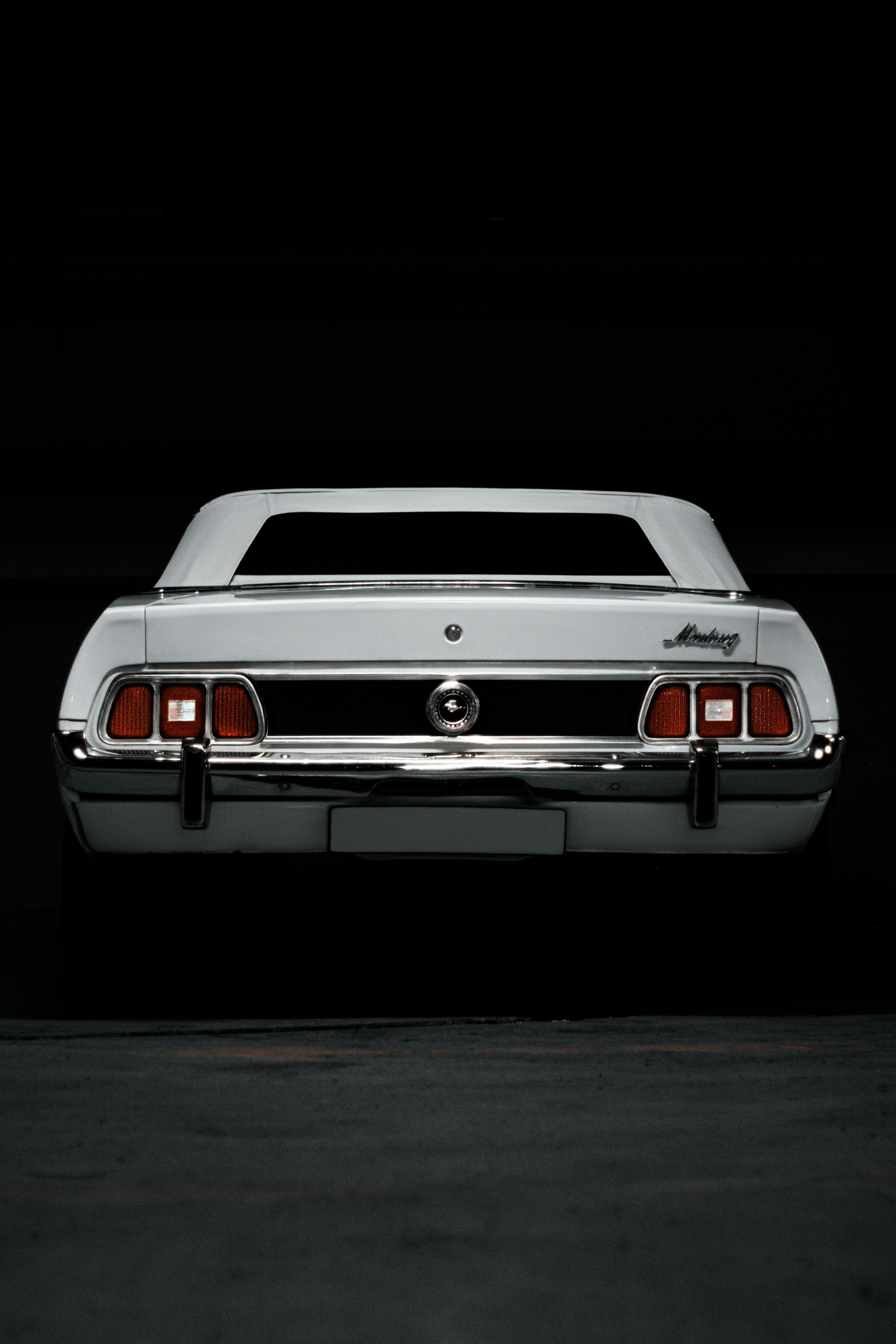 a white car parked in a dark room