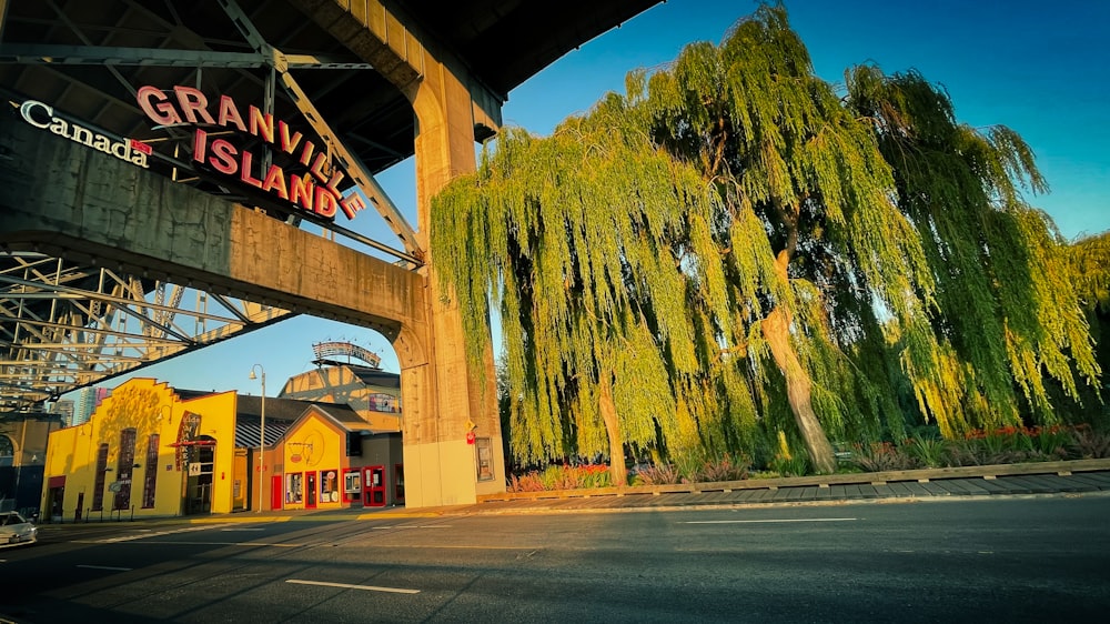 a bridge over a street with a building and trees