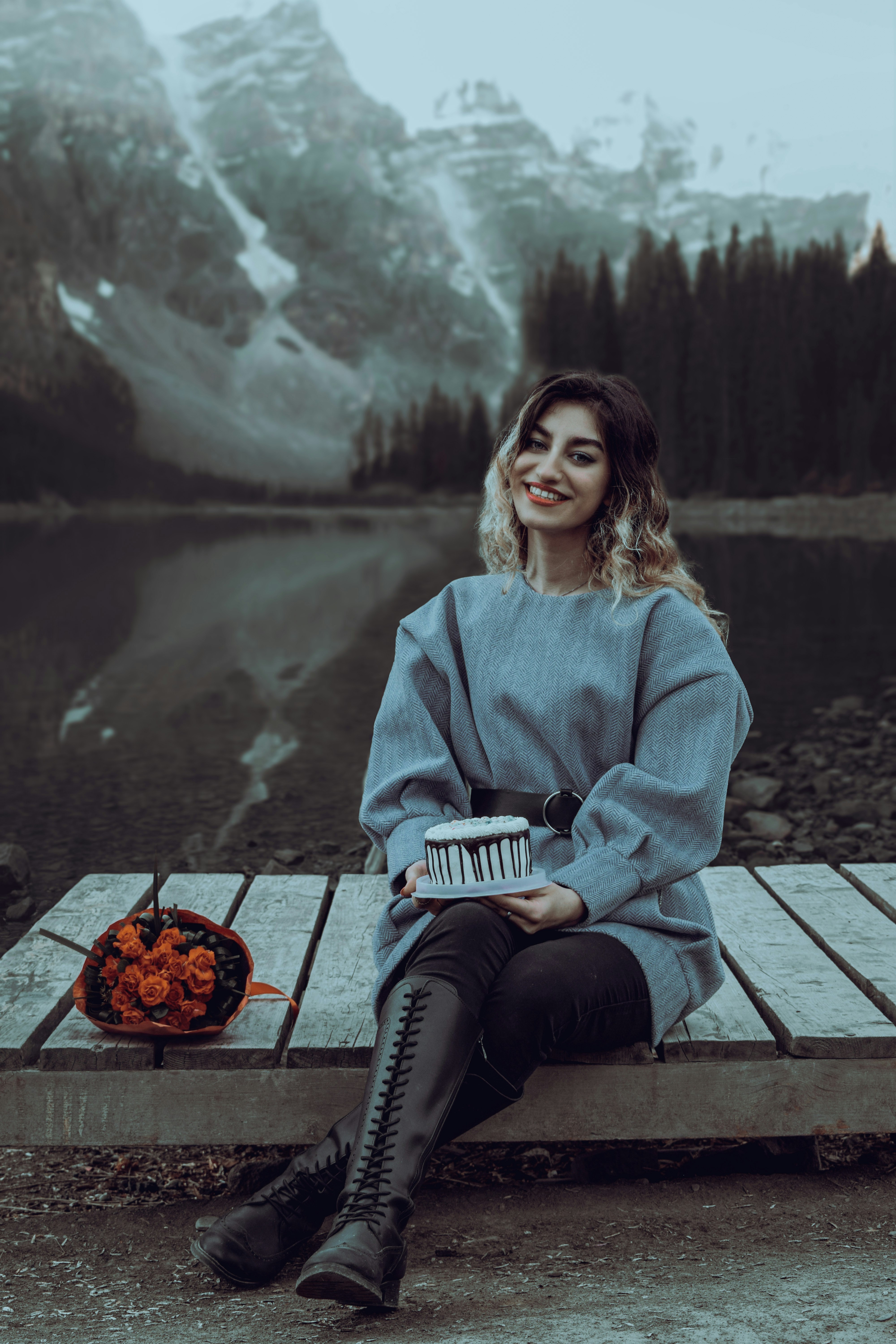 A woman sitting on a bench next to a lake photo – Free Iran Image on ...