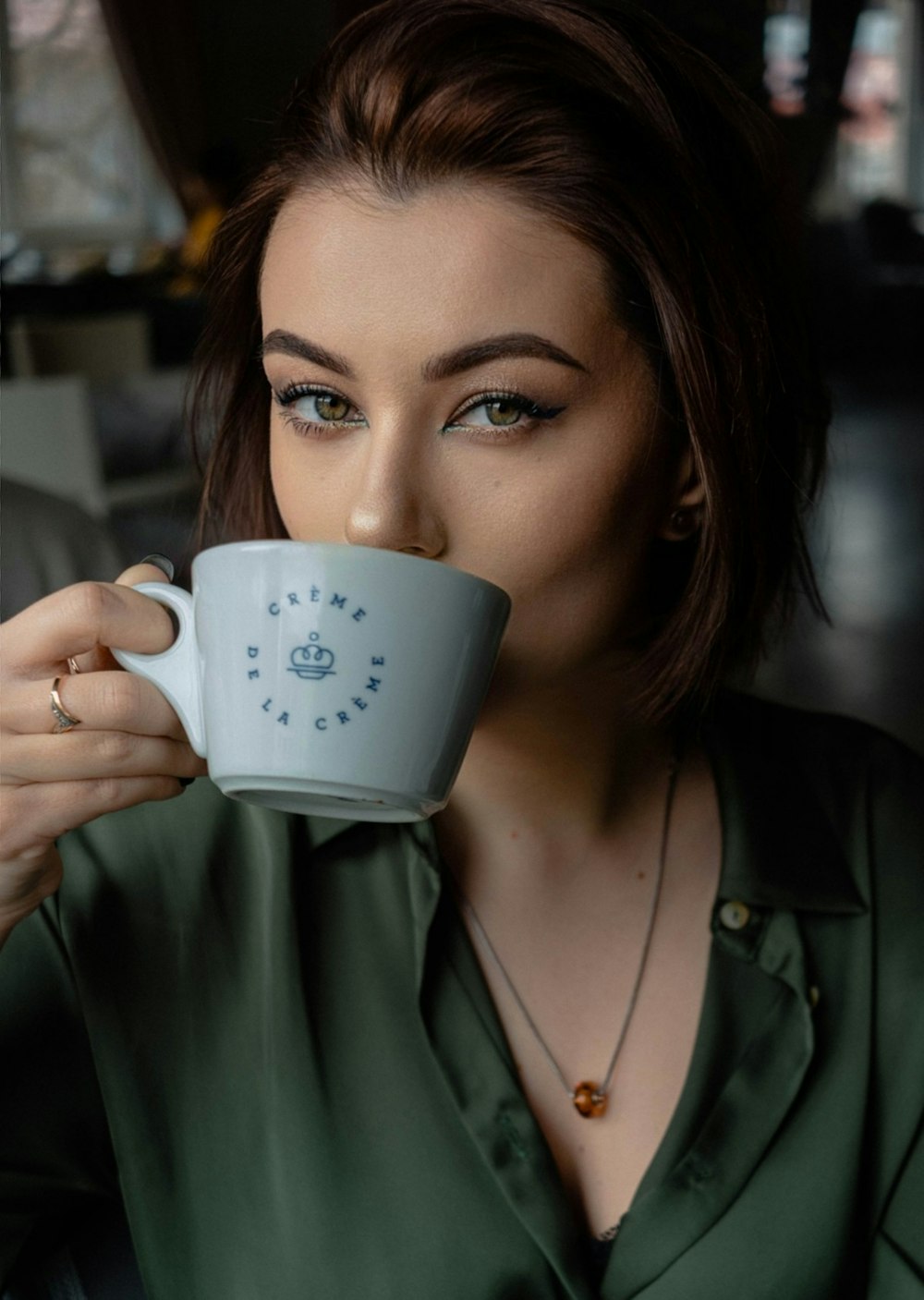 Una mujer sosteniendo una taza de café en su cara