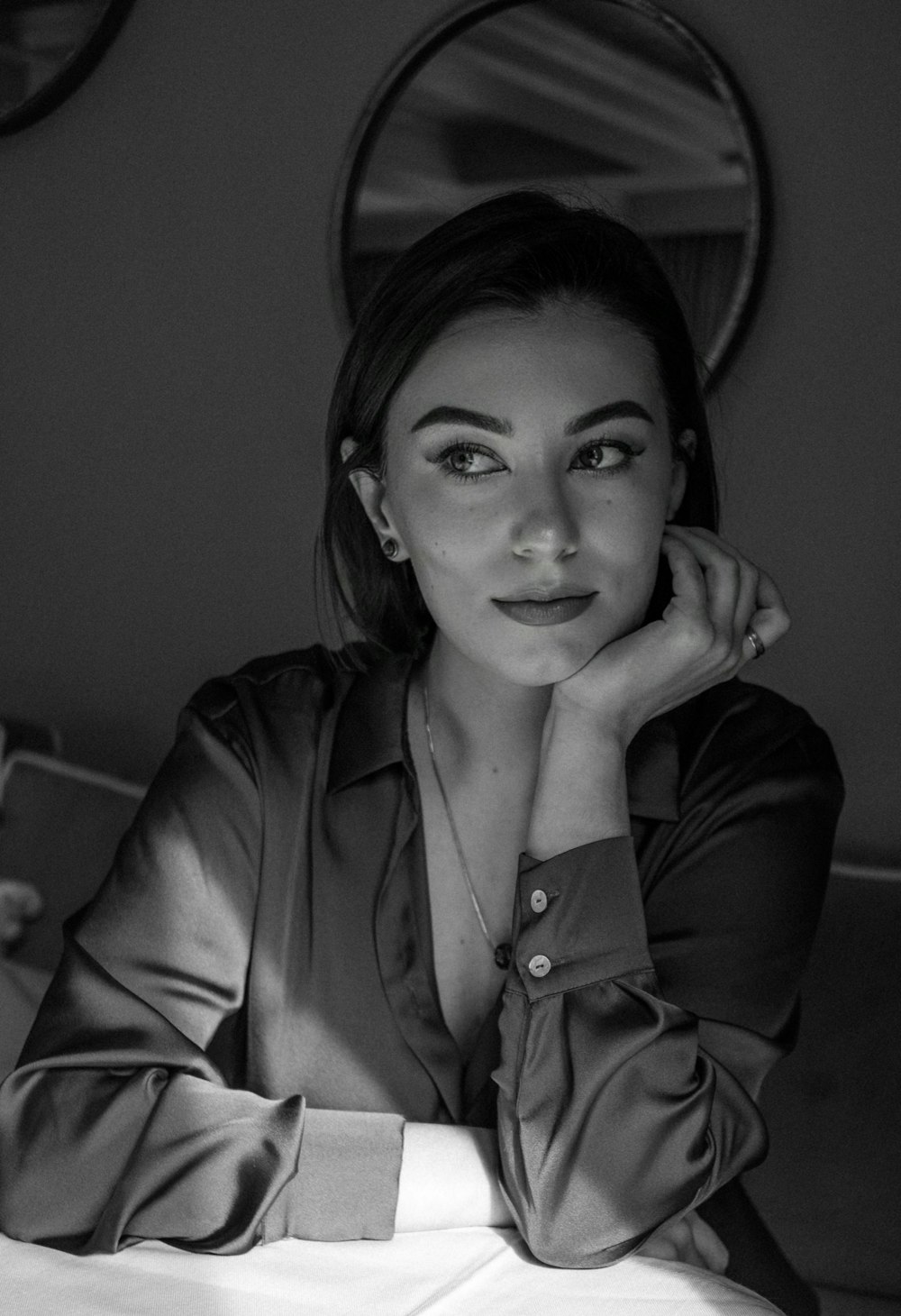 a black and white photo of a woman sitting at a table