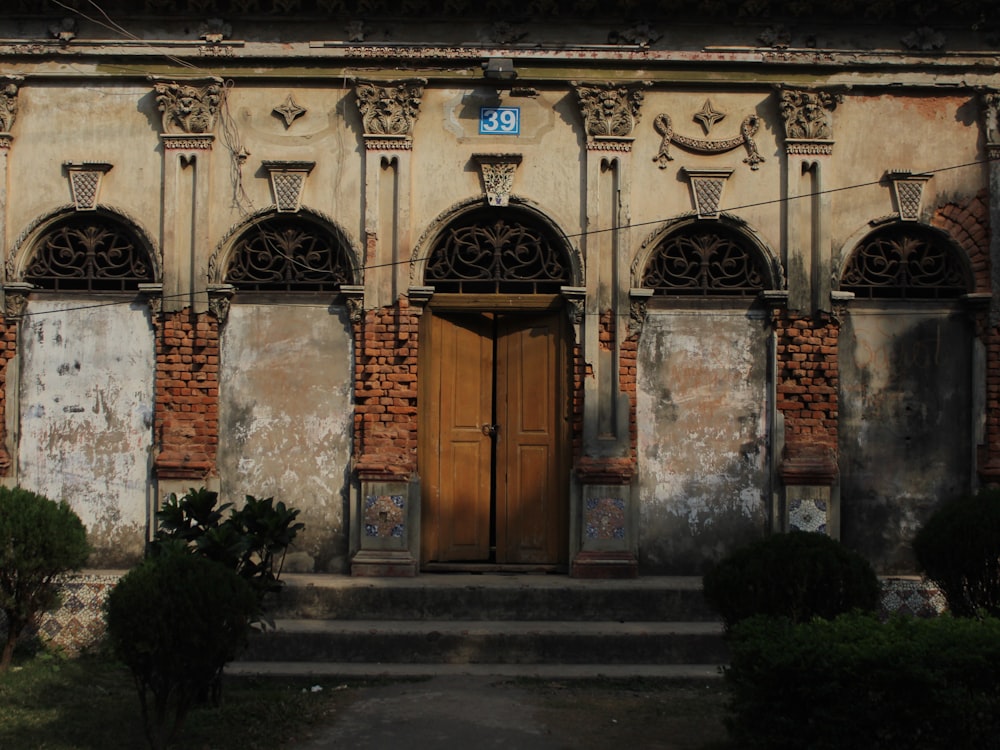 an old building with a wooden door and steps leading up to it