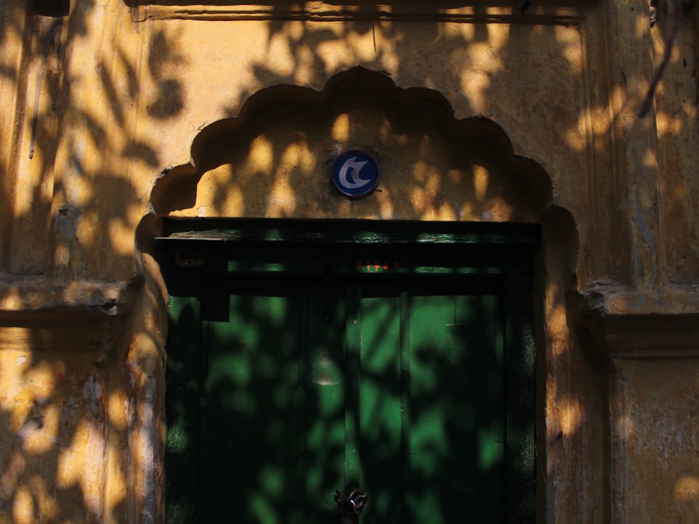 a green door with a blue and white sign on it