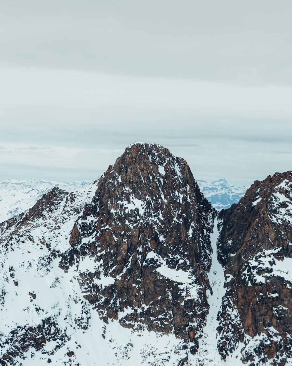 a mountain range covered in snow and clouds