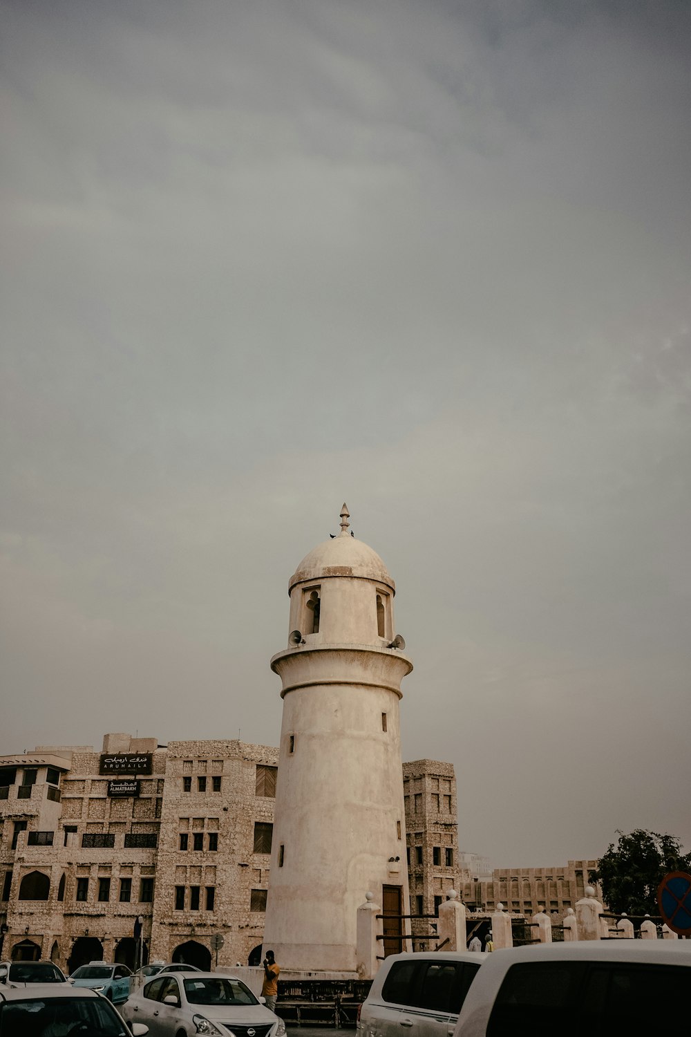 a tall white tower sitting next to a parking lot