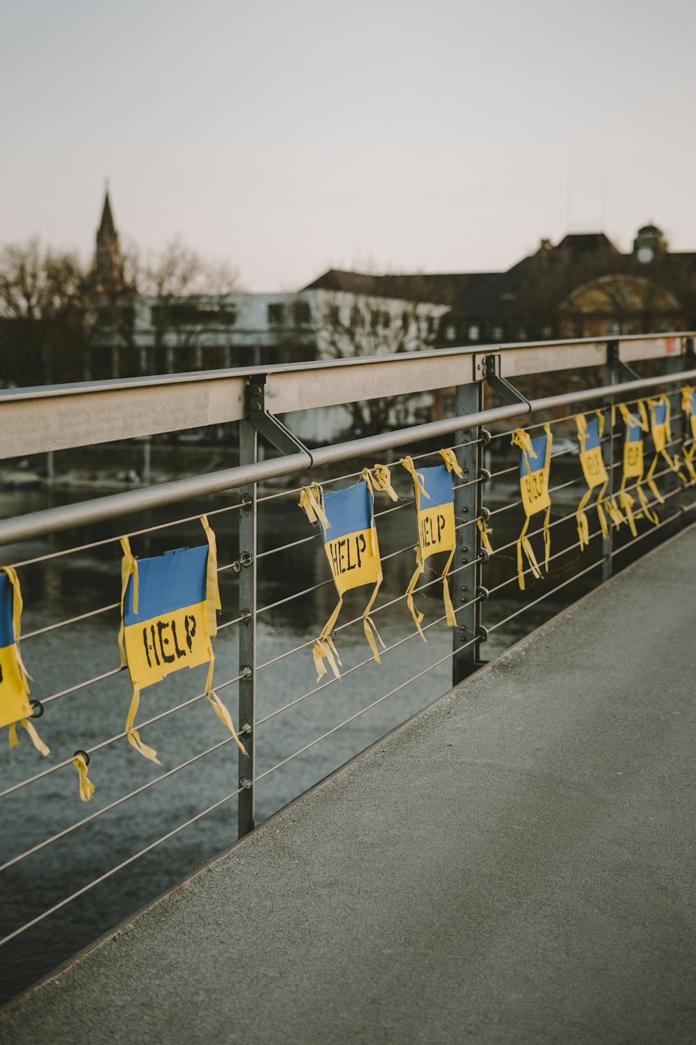 yellow and blue signs are hanging on a fence