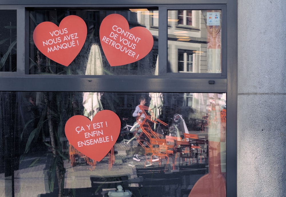 a couple of red heart shaped signs in a window