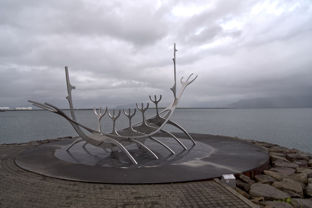 a metal sculpture sitting on top of a cement slab