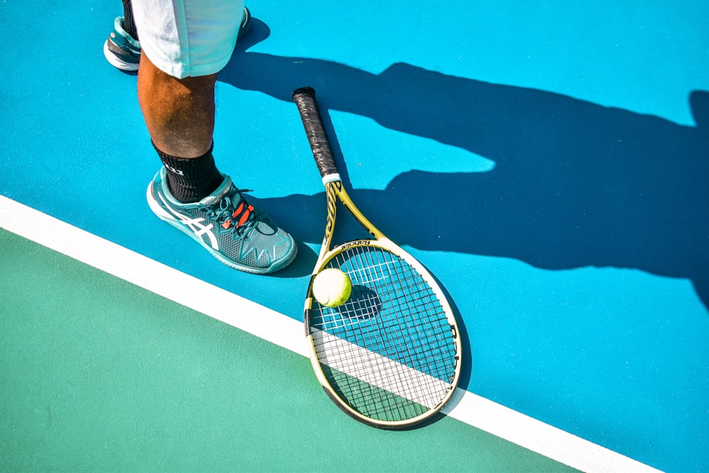 a person standing on a tennis court holding a tennis racket
