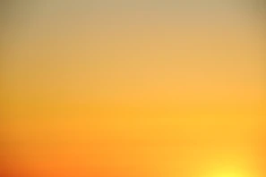 the sun is setting over the horizon of a body of water