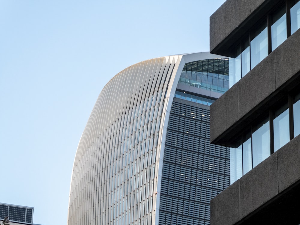a tall building with a curved roof next to other buildings