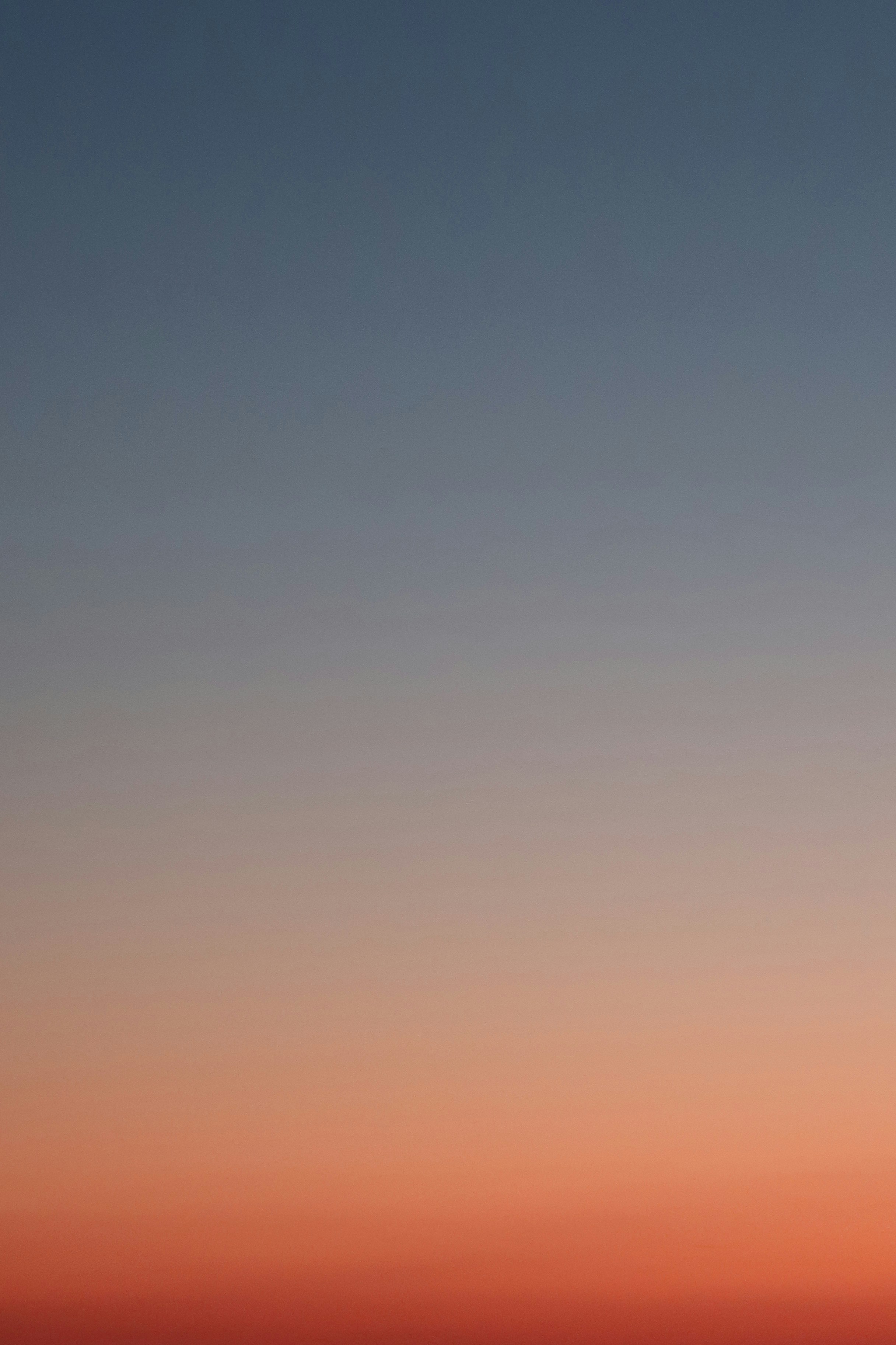 a plane flying in the sky at sunset