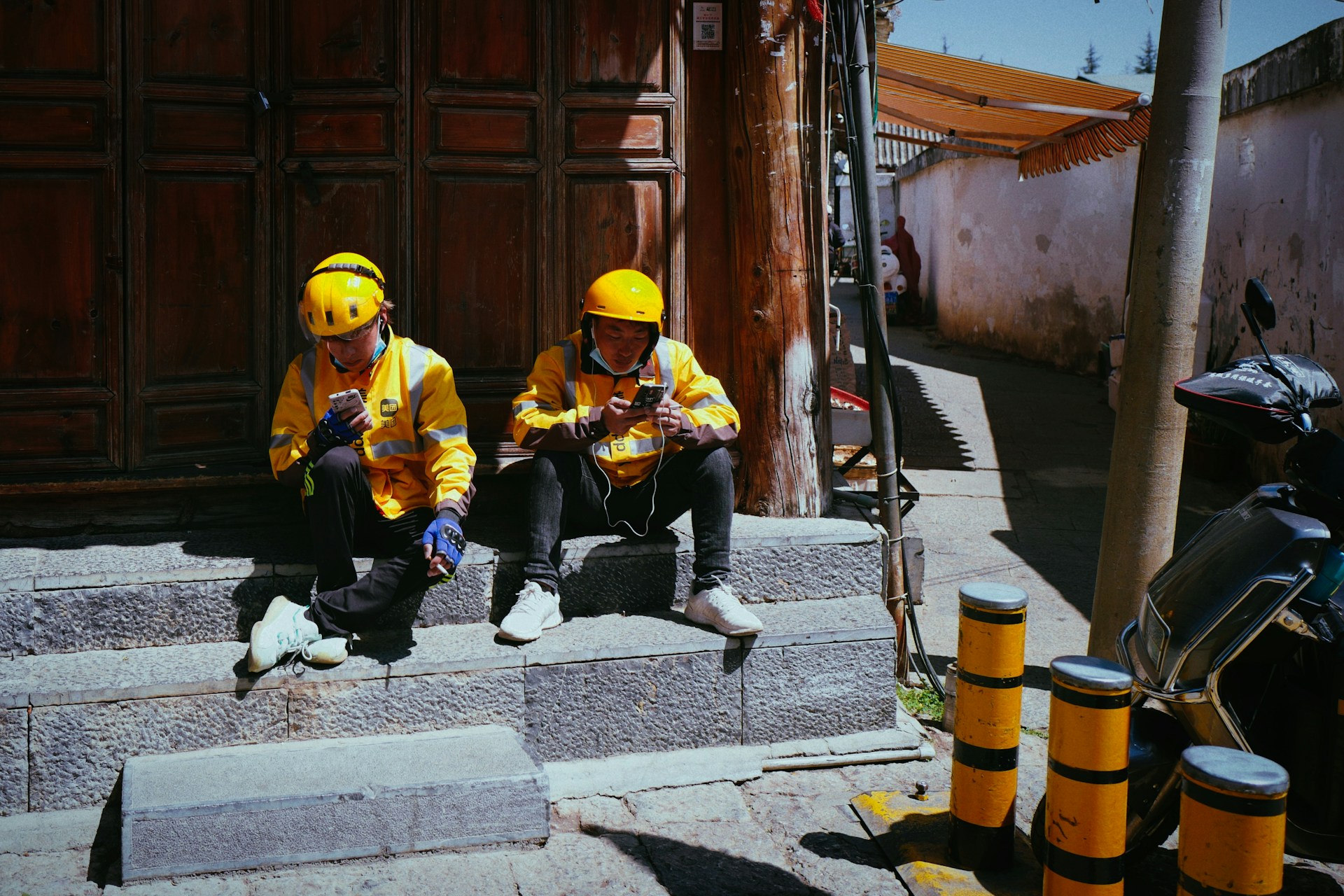 two people in yellow jackets sitting on steps