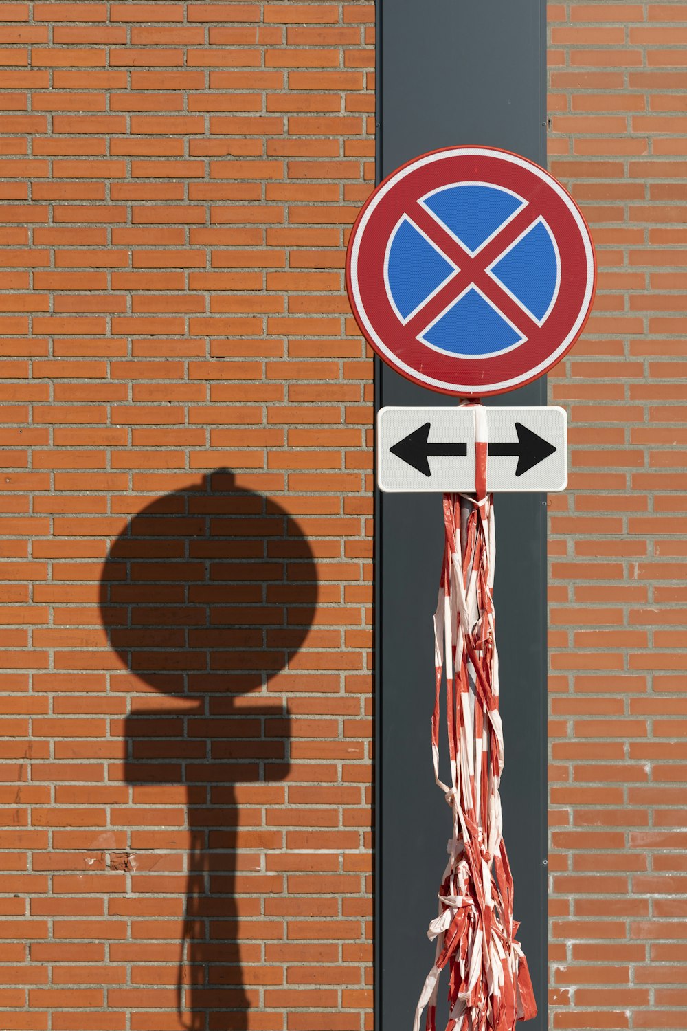 a street sign on a pole next to a brick wall