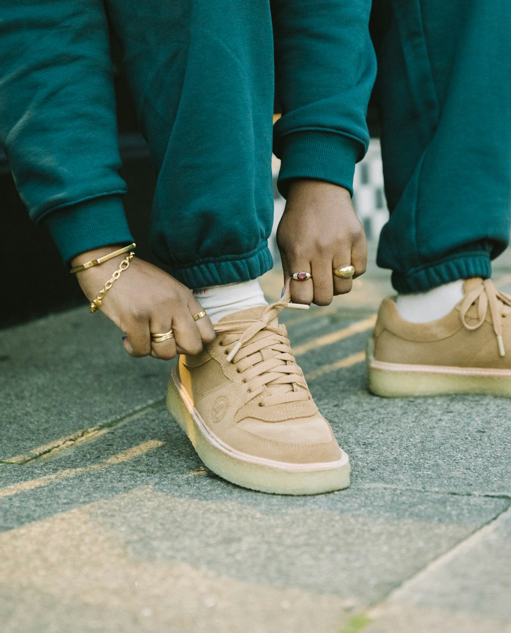 a person tying a pair of shoes with gold rings