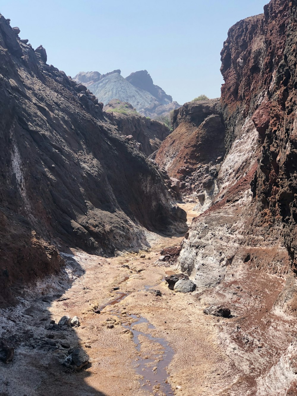 a narrow river in a canyon with mountains in the background