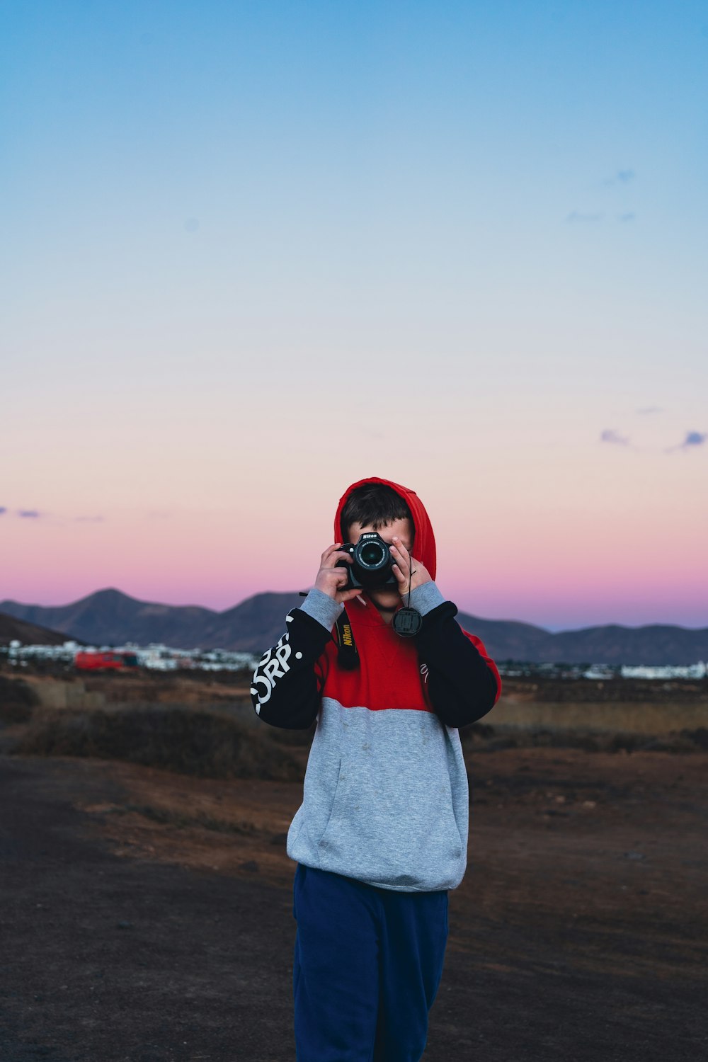 une personne debout devant un coucher de soleil