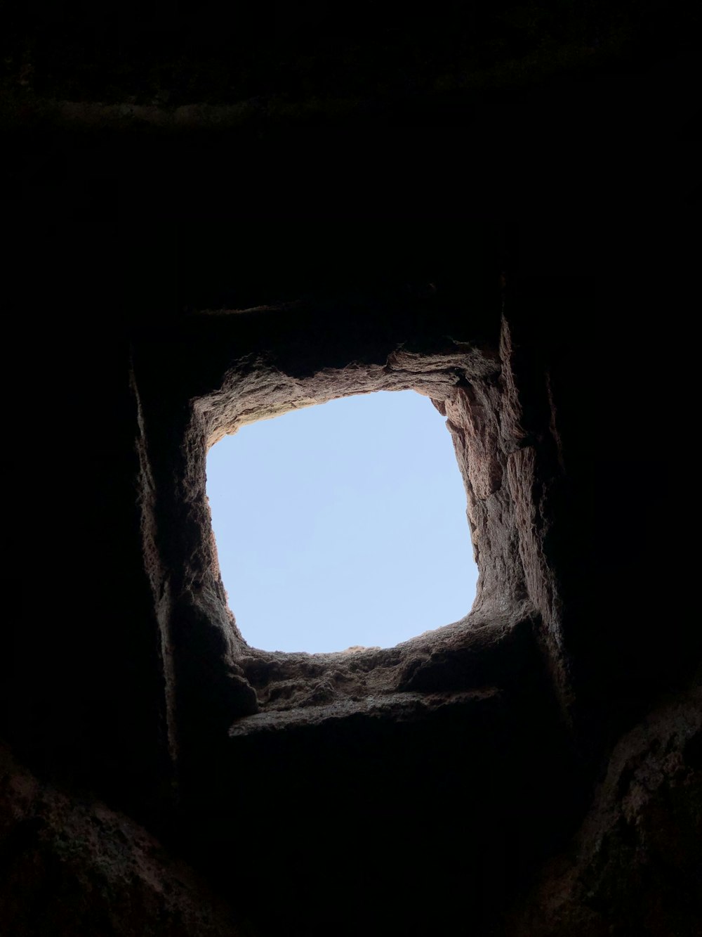 uma vista do céu através de uma janela em uma caverna