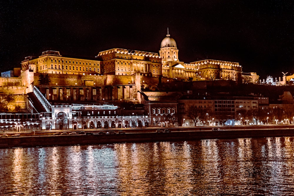 a night view of a city with a castle in the background