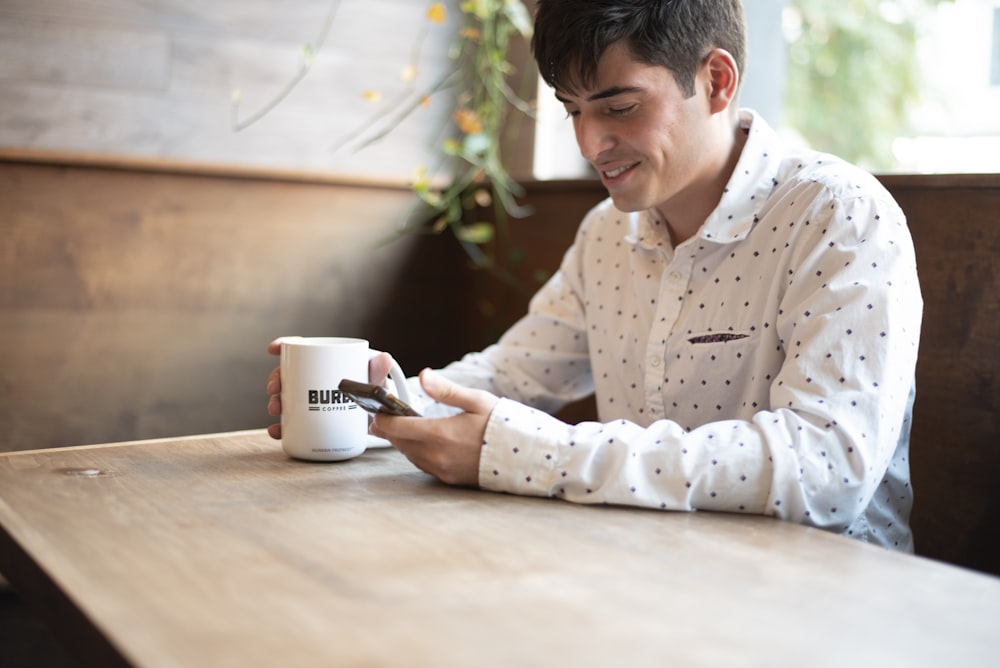 a man sitting at a table looking at his cell phone