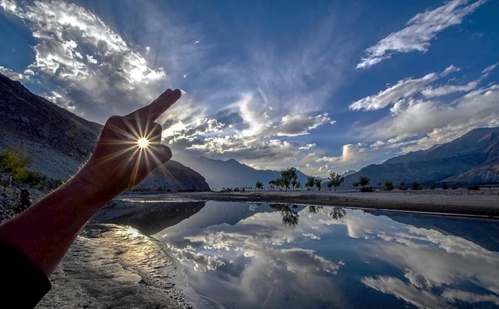 a person holding their hand up to the sky