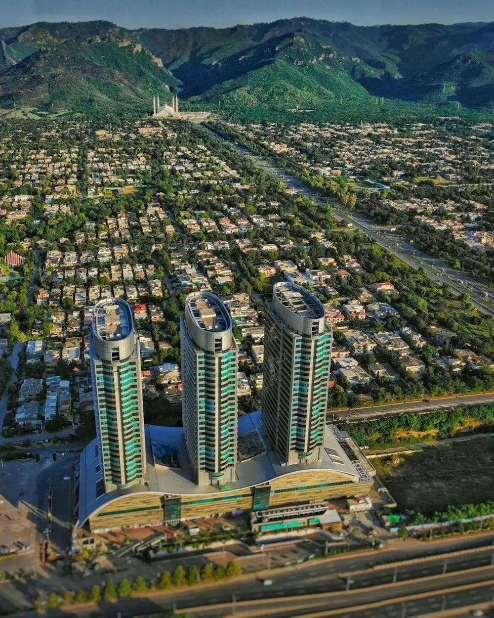 an aerial view of a city with mountains in the background