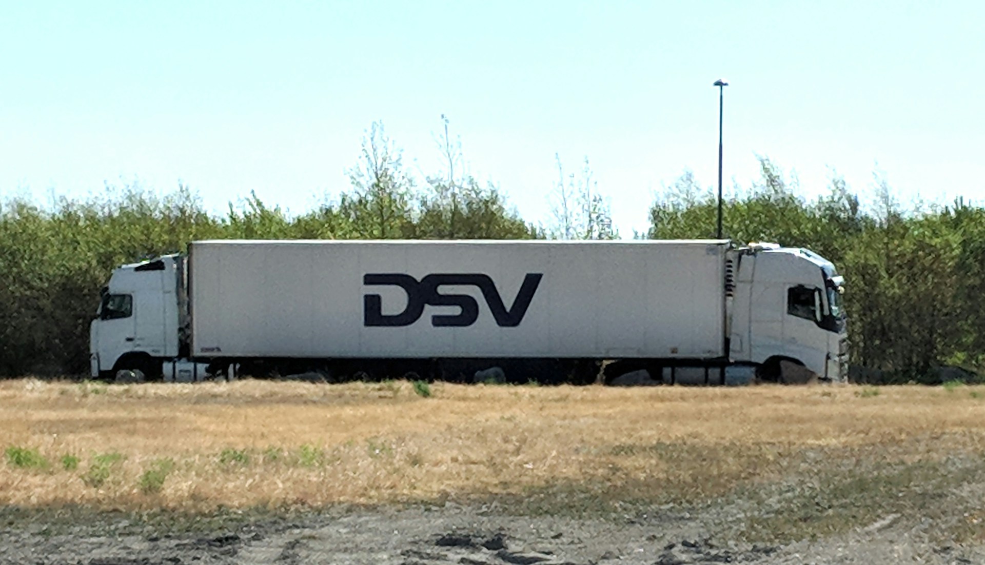a white truck driving down a dirt road