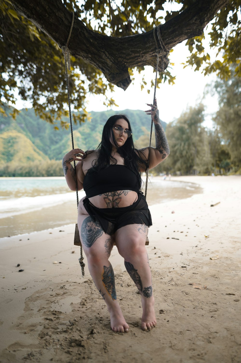 a woman in a black top is on a swing