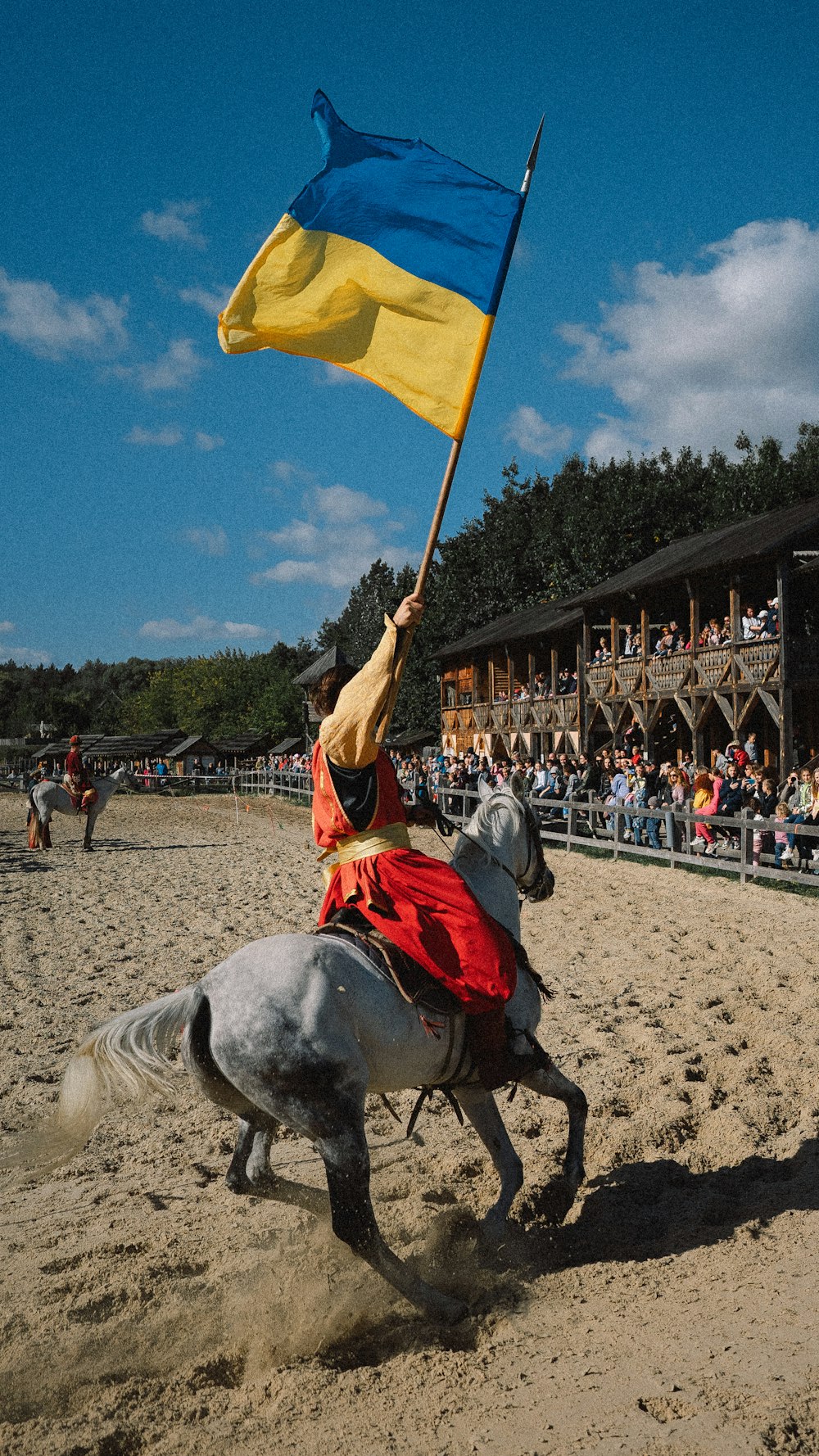 Un hombre montando un caballo sosteniendo una bandera