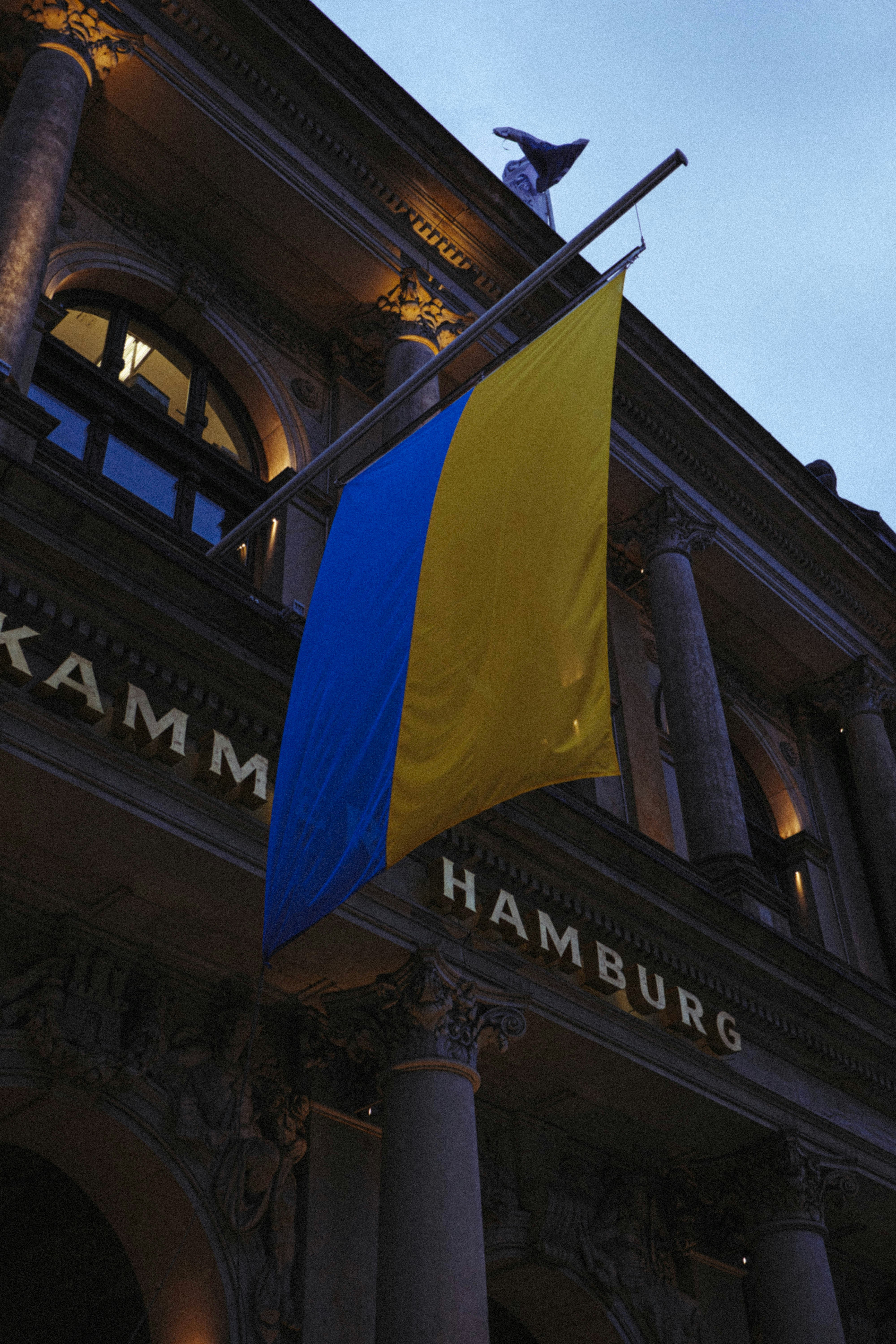 a blue and yellow flag hanging from the side of a building