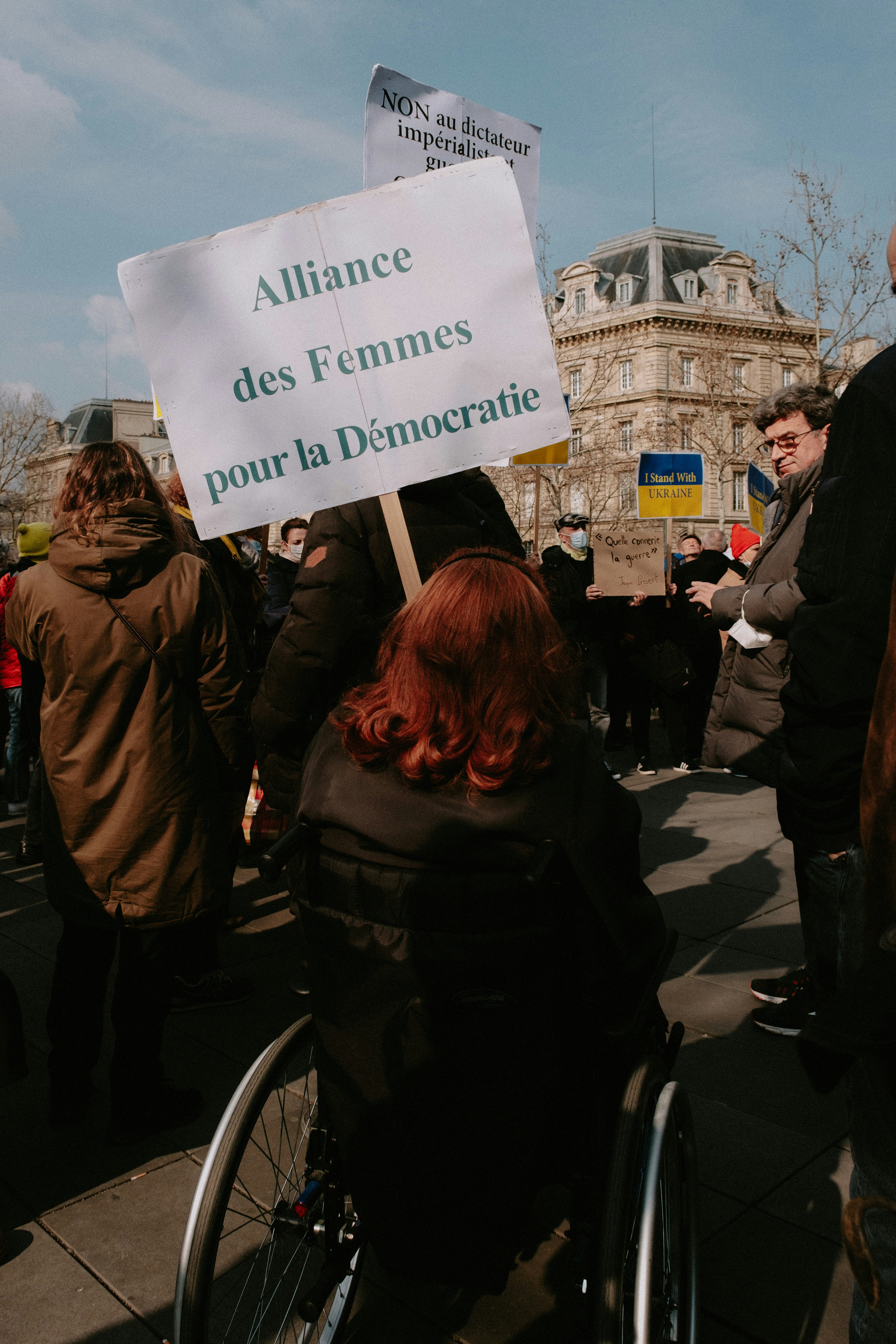 a woman in a wheel chair holding a sign