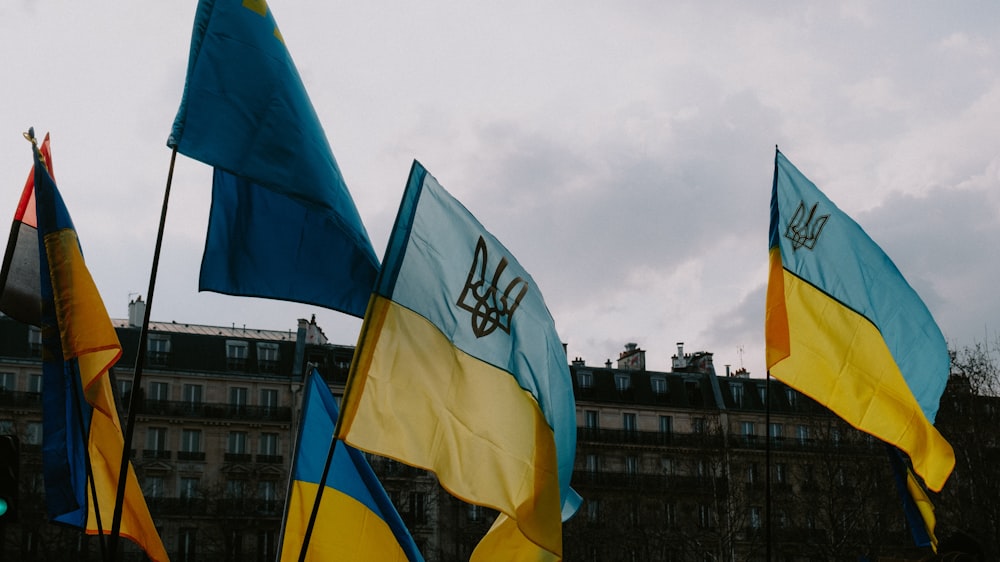 a group of flags with a building in the background