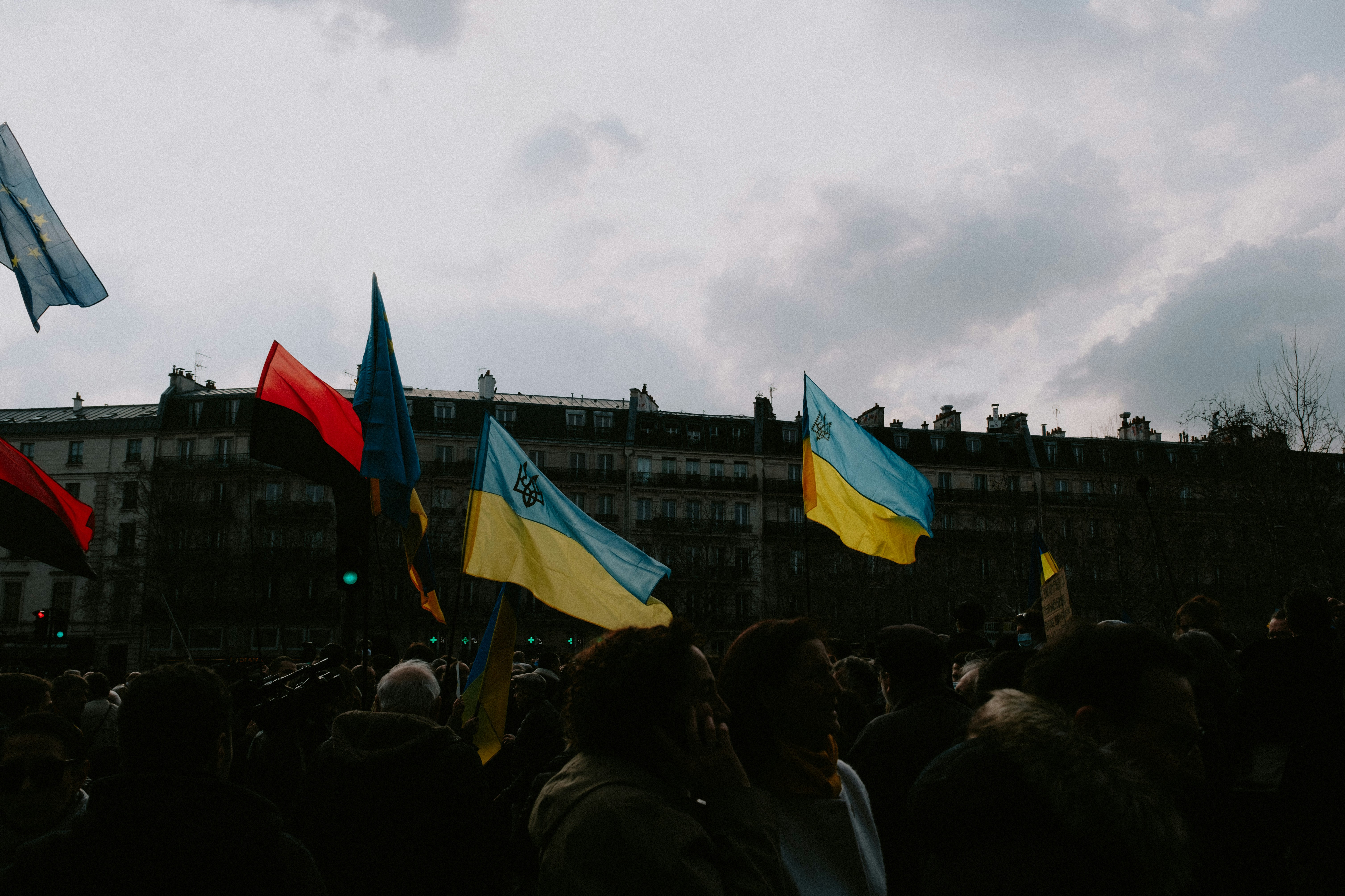 a crowd of people standing next to each other holding flags