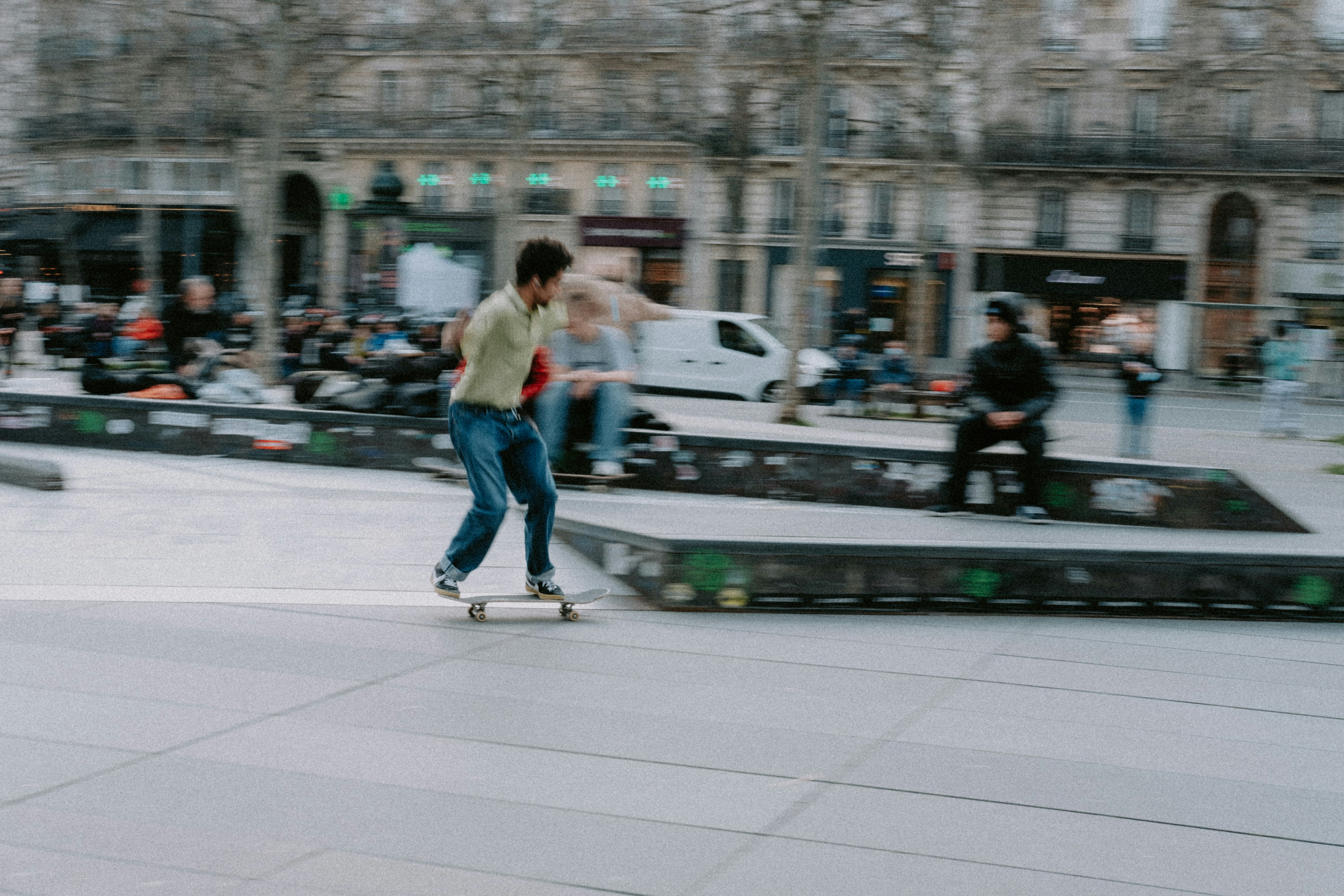 a man riding a skateboard down a sidewalk, 