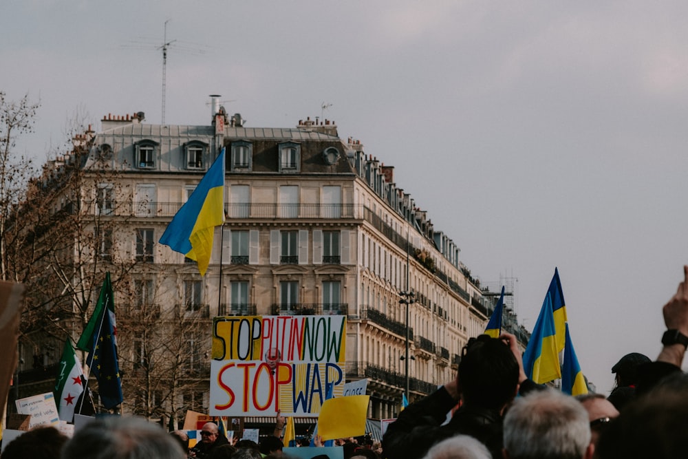 a crowd of people holding signs and flags