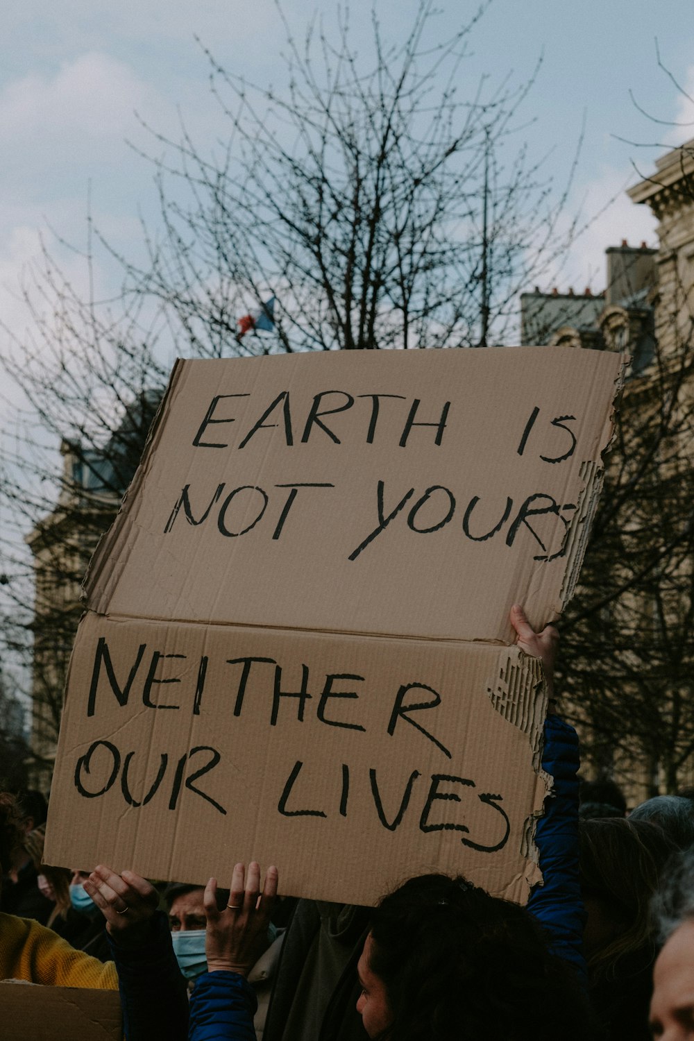 a group of people holding a sign that says earth is not your nether lives