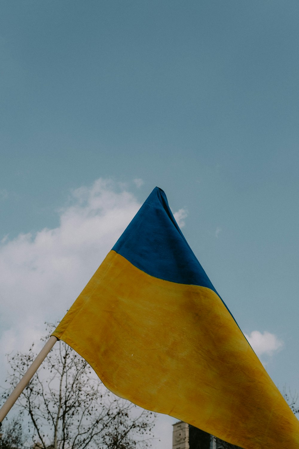 a yellow and blue flag flying in the sky