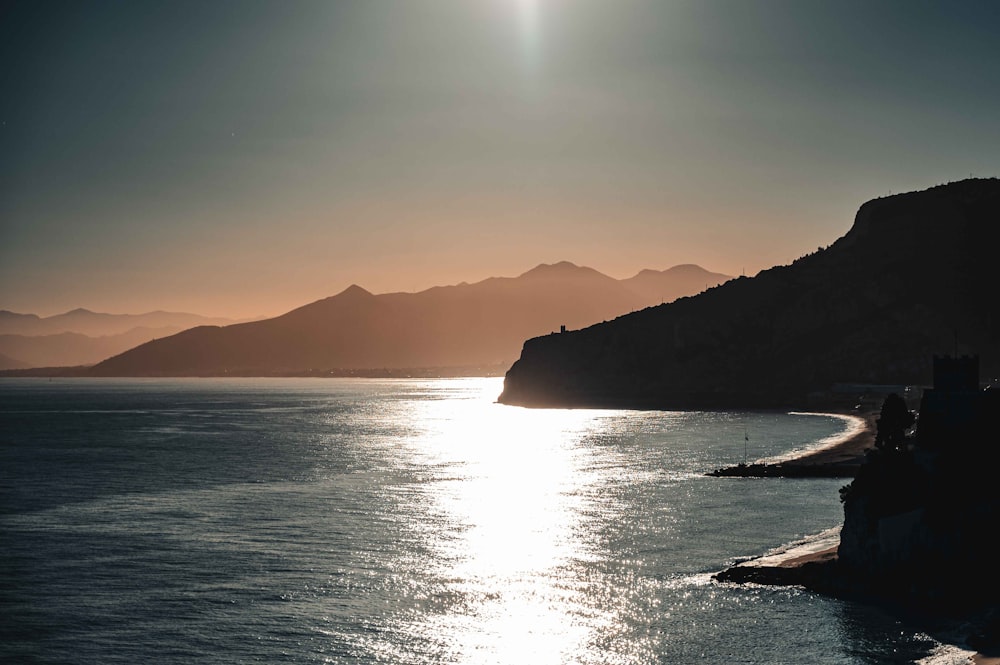 Die Sonne scheint über Wasser und Bergen