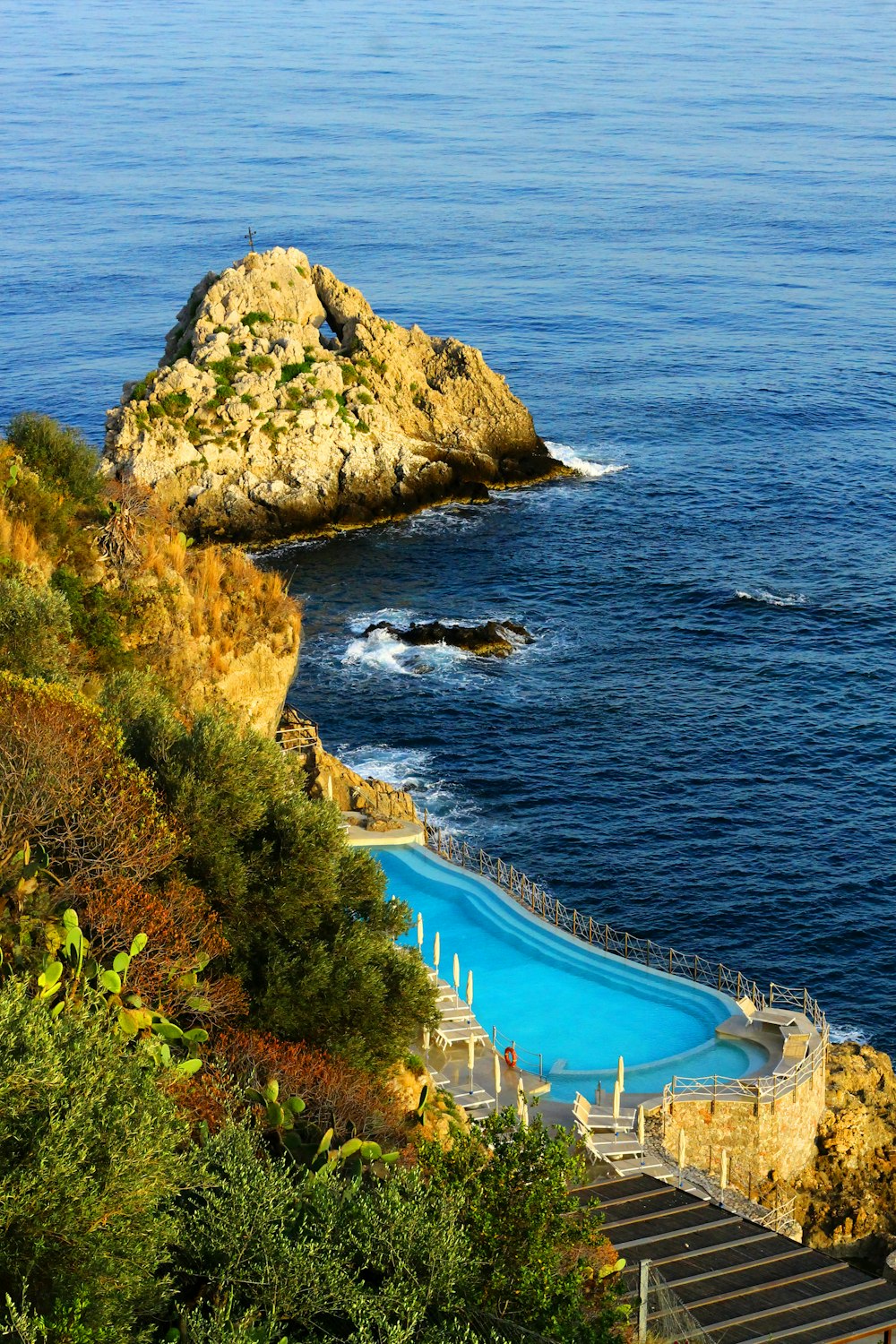 una piscina en la ladera de un acantilado junto al océano